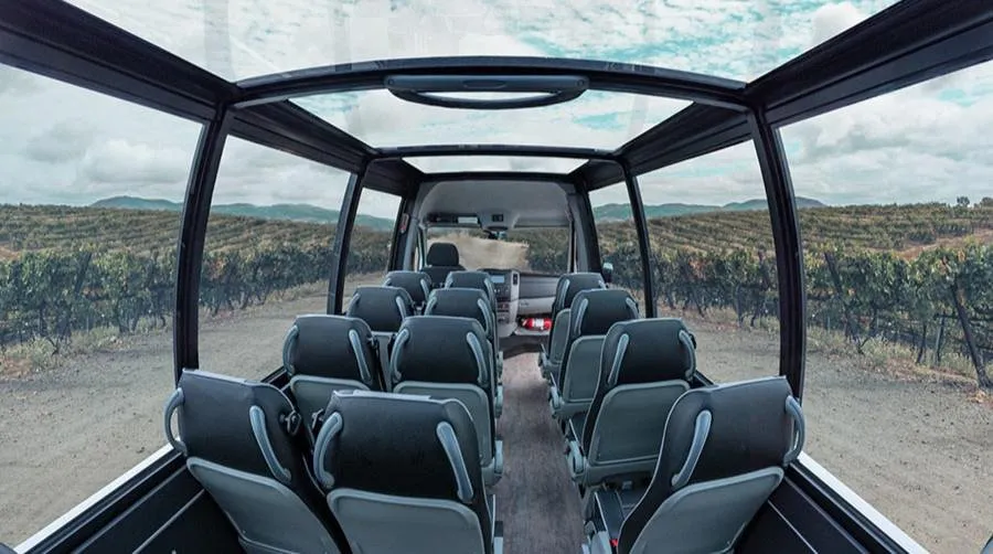 Interior view of a Mercedes convertible shuttle with a sprawling vista of vineyards 