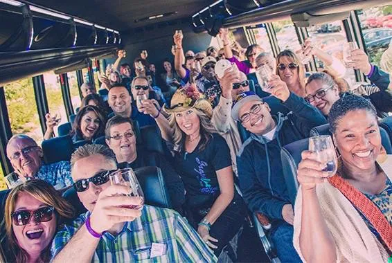 Lots of people raising glasses on a Grapeline shuttle