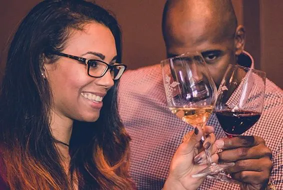 A couple tasting red and white wine