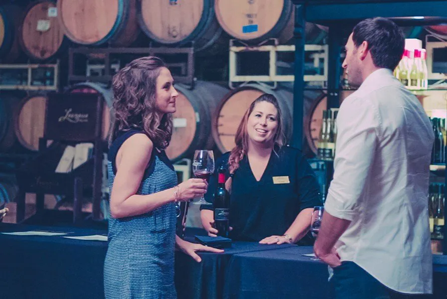 Couple with wine server in Paso Robles barrel room