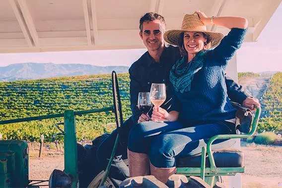 Grapeline founders John and Kim on a tractor