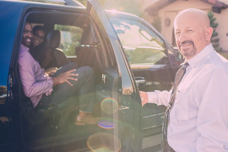 Chauffeur opening door for wine tour couple